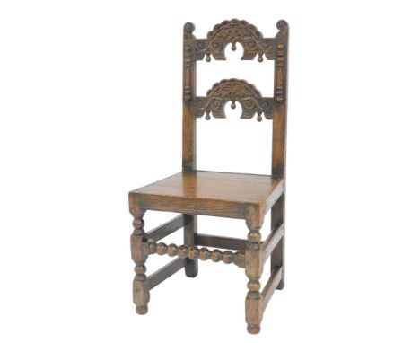 A late 17thC oak back stool, probably Yorkshire, with a carved back, solid seat, raised on turned legs united by plain and bo