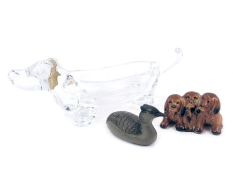 A Vannes le Chatel glass trinket dish, modelled as a dachshund, partial paper label, 26cm wide, together with a Poole pottery