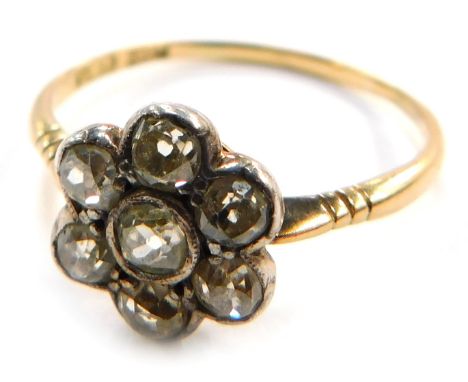 An Edwardian diamond flower head dress ring, miligrain set with seven stones, yellow metal shank marked 18ct, size T 1/2, 2.5