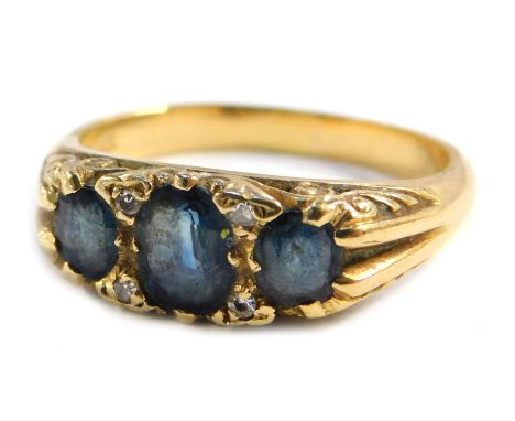 A sapphire and diamond dress ring, set with three marquise cut sapphires, with tiny diamond breaks, on a yellow metal shank, 