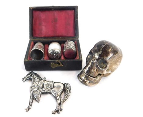 A silver match striker, modelled as a skull, together with a brooch modelled as a horse, stamped Sterling, 1.49oz, a thimble 