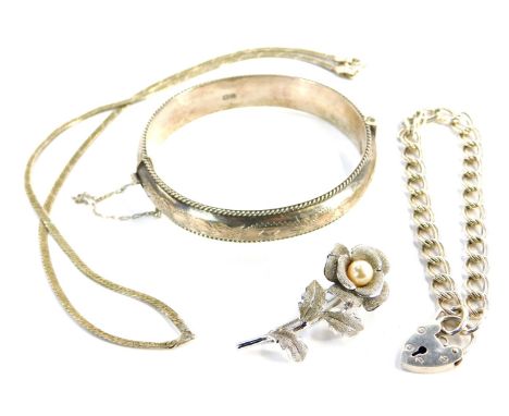 A silver hinged bangle and a chain link bracelet, the bangle with engraved decoration, the bracelet with padlock clasp, a mod