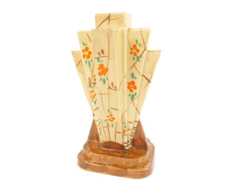 An Art Deco Myott Son and Co pottery fan shaped vase, decorated with orange flowers against a cream ground, on a brown steppe