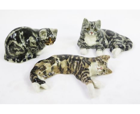 A large Winstanley pottery figurine, depicting a seated tabby cat with inset glass eyes, 30cm long, together with two other W