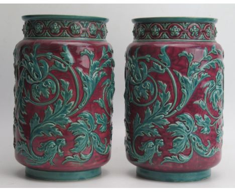 A pair of Zsolnay Pecs cylindrical vases, with low relief green foliate decoration to a puce ground, impressed marks to base 