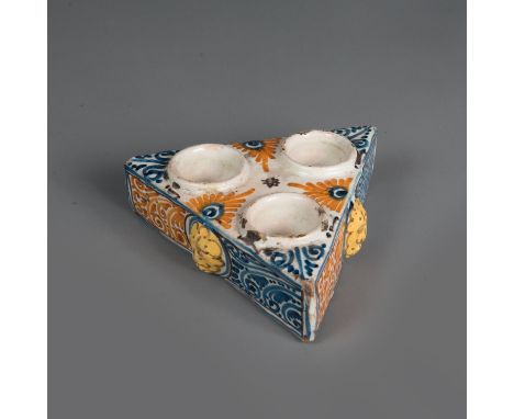 Spanish ceramic inkwell in triangle shape with three deepened bowls and three lion faces painted. Glaced. Around 1700. 14 x 1