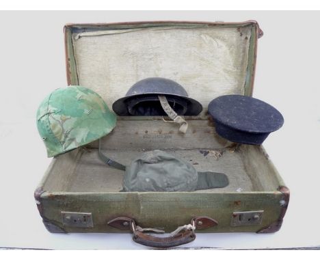 An American helmet, an ARP helmet, a sailor's hat, and German cap, all in a suitcase named for D E Livesely, D 120661Y, RAF, 