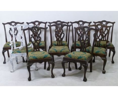 A set of ten reproduction mahogany dining chairs, including two carvers, Chippendale style with open strapwork splats, carved