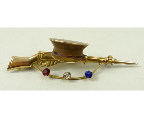 A First World War 9ct gold Army sweetheart brooch with an Enfield rifle surmounted by a cap and having a swag below, set with