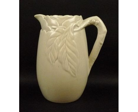 A Clarice Cliff buff pottery jug, Newport Pottery Co., with moulded leaf and branch decoration, 25cm high. 