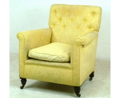 A Victorian armchair, with scroll over arms, turned front legs with brass castors, upholstered in cream button back fabric wi