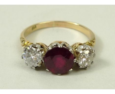 An 18ct gold, diamond and ruby three stone ring, the central ruby approximately 1.15ct flanked by two diamonds approximately 