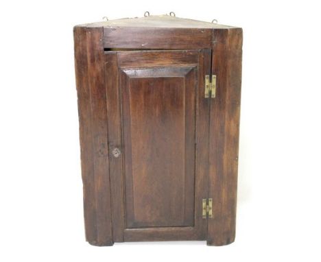 An 18th century oak corner cupboard with fielded panel door opening to reveal a single shelf, 64 by 34 by 94cm high.