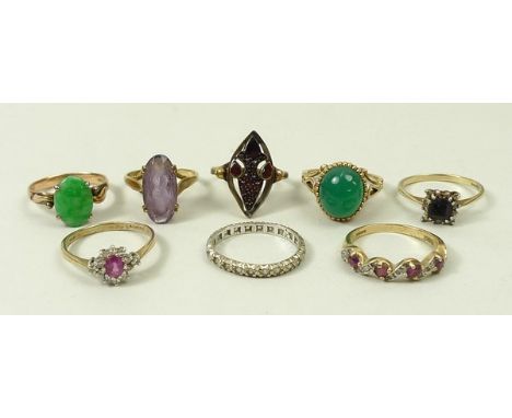 A quantity of 9ct gold gem set rings including a garnet set ring, jade ring, white gold and zircon set eternity ring, and a r