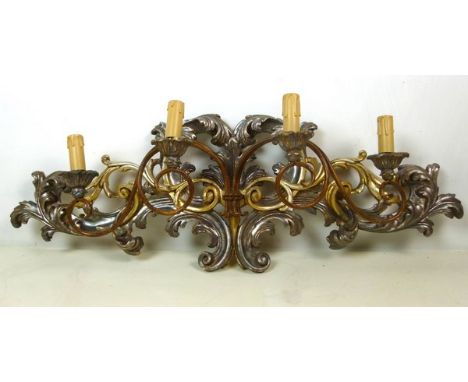 An 18th century Italian silver-gilt wall sconce, with four arms extending from the profusely carved scrollwork panel, 90 by 1