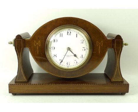 A Cross Brothers, Cardiff, mahogany cased mantel clock, enamel dial bearing Arabic numerals, the case with boxwood inlay rais