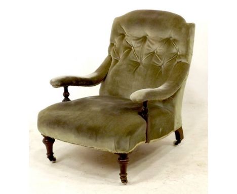 A Victorian mahogany framed low open armchair, upholstered in green button back velvet, turned front supports and white ceram
