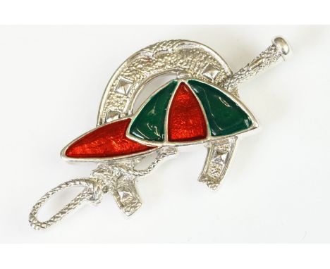 A silver and enamel brooch in the form of a horse shoe whip and cap 