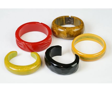 A cherry bakelite bangle together with four others. 
