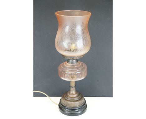 Late 19th / early 20th century oil lamp, the pink glass frosted shade with floral detail, over a glass font and gadrooned bas