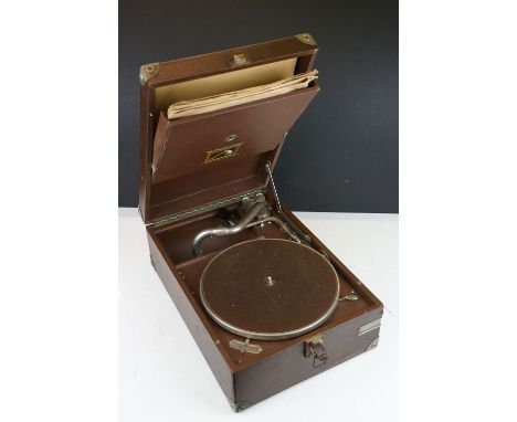 A vintage HMV portable wind up record player together with a quantity of records. 