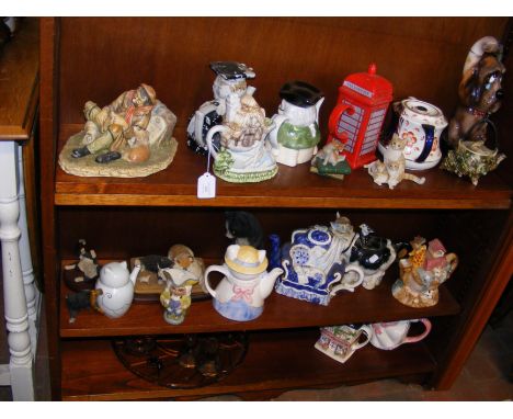 A collection of novelty teapots, cat ornaments and other collectable ceramic and glass - on three shelves 