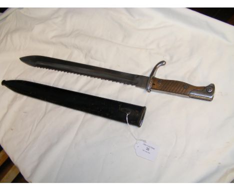 A WWII saw back sword bayonet with steel scabbard - the blade marked 'Waffenfabrik' - 52cm long overall