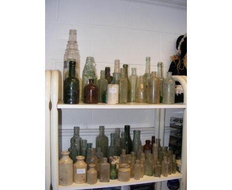 Assorted glass and ceramic dig bottles, including Isle of Wight Codd bottles - on two shelves 