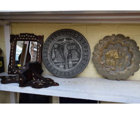 A Turkish hardwood and shell inlaid mirror; together with a similar wall bracket; a pewter charger; and a similar brass embos
