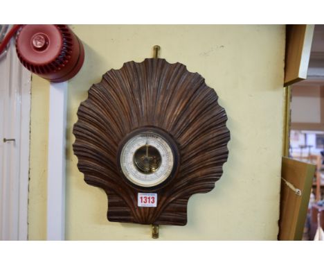 An unusual carved walnut scallop shell aneroid wall barometer, 26.5cm wide. 