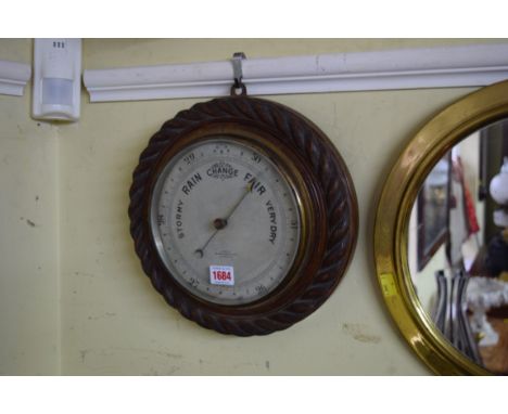 An early 20th century oak ropetwist framed aneroid barometer, the silver dial inscribed 'Dixey, Brighton', 29cm diameter. 