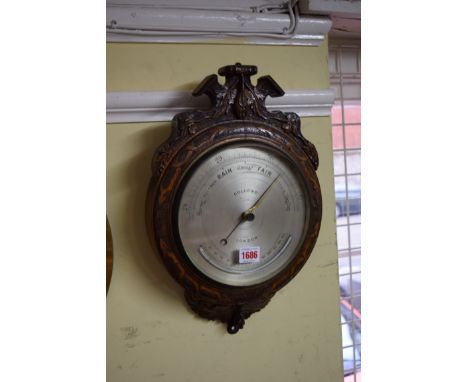 A Victorian carved walnut framed aneroid barometer, the silvered circular dial inscribed 'Dollond, London', numbered 5362, wi