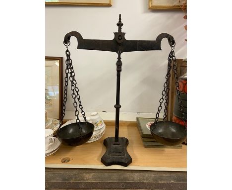 a set of 18th Century cast beam balance scales with metal bowls on chains and a cast metal base stand  