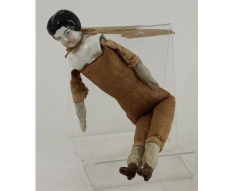 A miniature Victorian doll with ceramic head composition arms and legs and fabric body 
