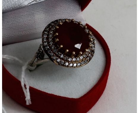 A silver CZ and large central ruby ring 