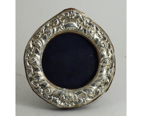 A silver embossed round picture frame on easel back 