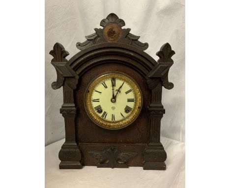 AN EBONISED MANTEL CLOCK WITH DECORATIVE EDGING AND BRASS DETAIL 