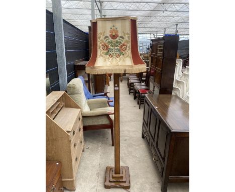 AN EARLY 20TH CENTURY OAK STANDARD LAMP COMPLETE WITH SHADE 