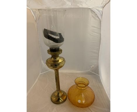 A LARGE BRASS OIL LAMP WITH CLEAR GLASS CHIMNEY AND SHADE AND AN AMBER GLASS SHADE 