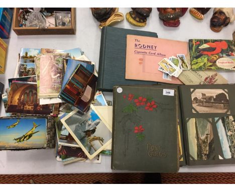 A LARGE COLLECTION OF VINTAGE POSTCARD ALBUMS AND LOOSE POSTCARDS AND CIGARETTE AND TEA CARD ALBUMS 
