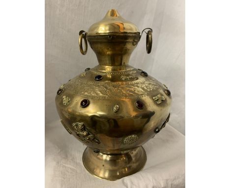 A LARGE BRASS TWIN HANDLED AND LIDDED URN WITH RED STONE DECORATIVE DETAIL H:APPROX. 35CM 