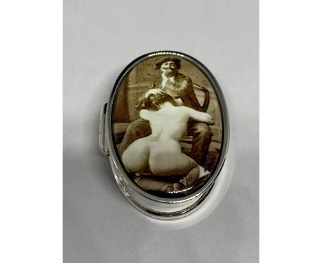 A SILVER PILL BOX WITH AN ENAMEL EROTIC DESIGN ON THE LID 