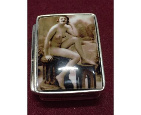 A SILVER PILL BOX WITH AN ENAMEL EROTIC DESIGN ON THE LID 