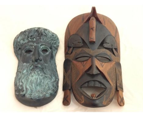 A HARDWOOD CARVED TRIBAL MASK AND A GREEK CERAMIC MASK OF ZEUS 