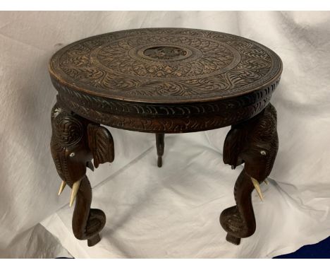 A HEAVILY CARVED ANGLO-INDIAN ROSEWOOD TRIPOD TABLE SUPPORTED ON ELEPHANT HEAD AND TRUNK LEGS H: 40CM 