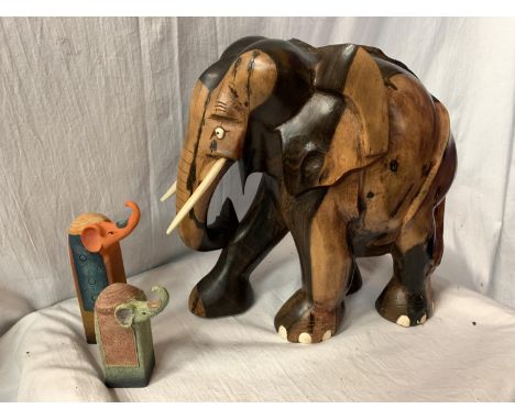 A LARGE CARVED HEAVY HARD WOOD ELEPHANT (H: APPROX. 30CM) AND TWO CERAMIC ELEPHANT ITEMS 