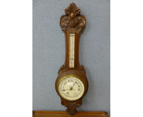 A carved walnut aneroid barometer 