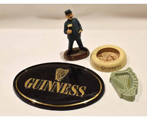 Group of Guinness collectables including an Ashtead ash tray with a Sam Weller type design, a green glazed pottery model of a