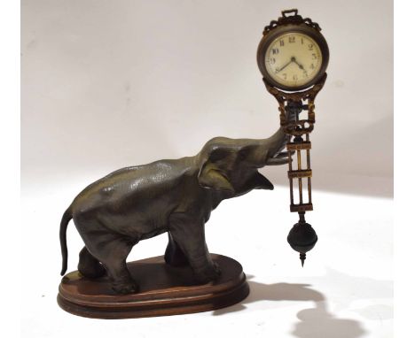 Bronzed metal mystery clock, modelled as an elephant with a clock balanced to its trunk, 31cm long
