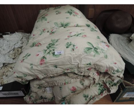 A vintage single bed eiderdown having floral decoration on pale pink ground